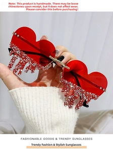 Close-up of heart-shaped sunglasses with sparkling rhinestone tassels dripping details