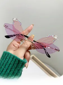 Detail of dragonfly wing sunglasses with pink gradient lenses and rhinestone accents