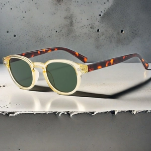 Detail view of oval retro sunglasses with champagne frames and tortoiseshell temples