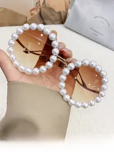 Detailed view of luxury round pearl sunglasses with gold metal wavy temples and gradient lenses