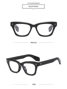 Detail of square black glasses frame with silver spear rivets and cat-eye style