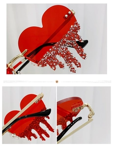 Detailed view of red heart sunglasses with dripping rhinestone fringe and gold frames