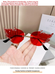 Macro shot of red flame-shaped sunglasses with crystal rhinestones on rimless lenses
