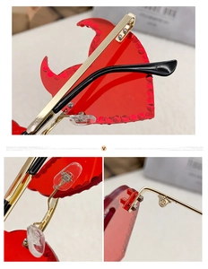 Detailed close-up of red rhinestone heart-shaped little devil sunglasses