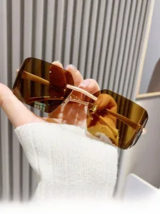 Détail de lunettes de soleil carrées sans monture avec verres bruns et pont doré