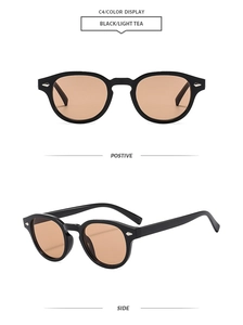 Detail of oval vintage sunglasses with black frame, light tea lenses, and silver arrow trim