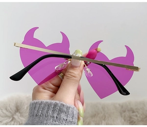 Detailed view of purple devil heart-shaped lenses with gold metal frames for party wear
