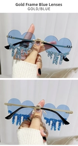 Detail of heart-shaped rimless sunglasses with blue lenses and dangling rhinestone tassels