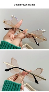 Close-up of rimless dragonfly wing sunglasses with gold frame, brown lenses and rhinestones