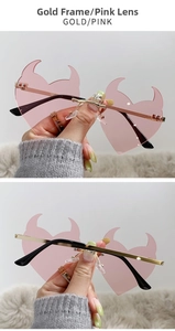 Detailed view of pink devil heart sunglasses with gold frame and gradient lenses