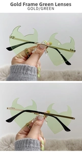 Detail of devil horn heart sunglasses with gold metal frame and green lenses