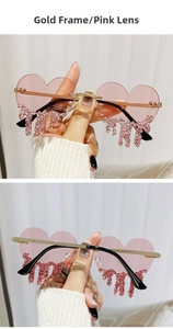 Detail of gold-rimmed heart-shaped pink sunglasses with stylish teardrop rhinestones