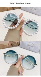 Detail of round luxury sunglasses featuring gold metal frame and pearl-encrusted rim
