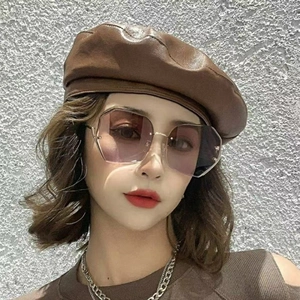 Detailed view of oversized geometric sunglasses with purple gradient lenses and gold metal frame