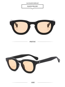 Detail view of oval retro sunglasses with thick black frames and yellow tinted lenses