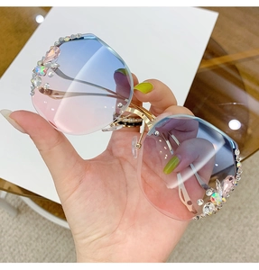 Close-up of gradient pink-blue oversized sunglasses with luxury rhinestone edge detail