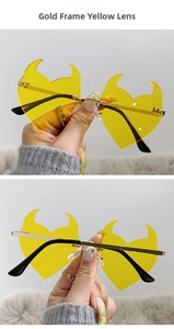 Detail of gold metal frame and yellow devil horn heart-shaped lenses with sturdy hinges