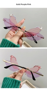 Detail of dragonfly wing sunglasses with rhinestones, gold frame and purple pink lenses