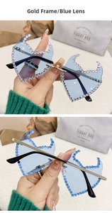 Detail of blue flame-shaped rimless sunglasses with sparkling rhinestones and gold frame