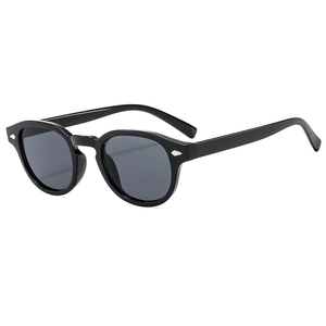 Vintage oval black sunglasses with silver rivet accents and grey lenses on white background