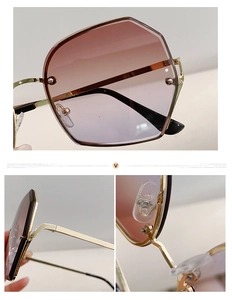 Detailed macro view of geometric metal hinges and pink gradient lenses on gold sunglasses