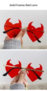 Detailed view of red heart devil sunglasses with gold metal frames and stylish red lenses