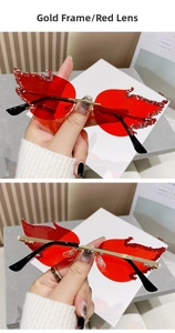 Detailed view of flame-shaped sunglasses with gold frame, red lenses, and rhinestones