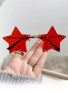 Close-up of rimless star-shaped sunglasses with red lenses and gold metal frame