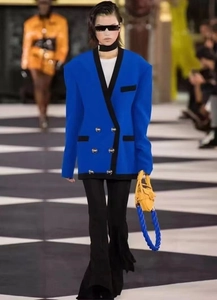 Gros plan du blazer croisé bleu futuriste avec épaulettes pointues et boutons argentés chic
