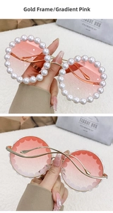 Detailed macro view of gold round sunglasses with gradient pink lenses and pearl trim