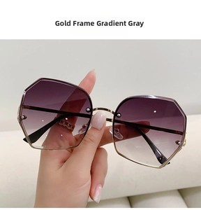 Detail of geometric gold metal frame sunglasses with gradient grey polygonal lenses