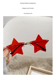 Close-up of red star-shaped rimless sunglasses with gold metal bridge for parties