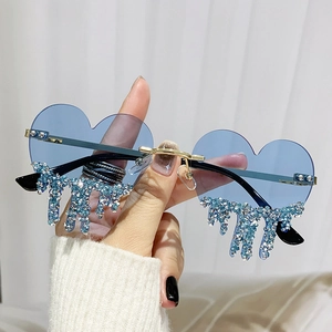 Fashionable heart-shaped rimless sunglasses with blue tinted lenses and rhinestone teardrops