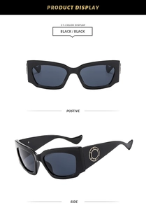 Détail de lunettes de soleil noires avec ornement circulaire doré sur la branche