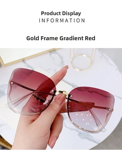 Close-up of gold metal rimless sunglasses with gradient red lenses on marble
