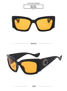 Détail des lunettes de soleil noires à verres jaunes avec décoration anneau doré