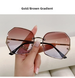 Close-up of gold metal frame polygon sunglasses with brown grey gradient lenses