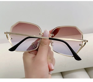 Detail of polygonal metal frame sunglasses with gradient lenses and slim golden temples