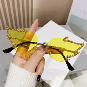 Frameless flame sunglasses with yellow lenses and sparkling gold rhinestones on lens edges