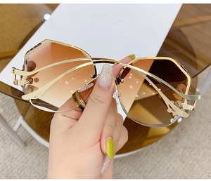 Detailed macro of gold metal temples with crystal accents and gradient brown lenses