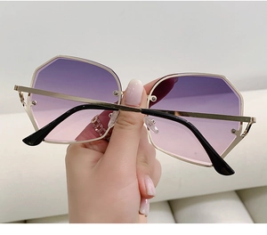 Detail of gradient purple lenses and slim gold metal frame on fashion oversized sunglasses