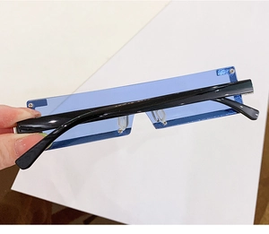 Gros plan de lunettes de soleil rectangulaires bleues sans monture avec branches noires