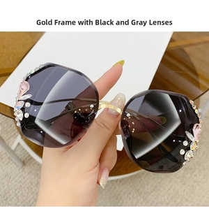 Detailed close-up of gold metal frame sunglasses with luxury rhinestones and gray lenses