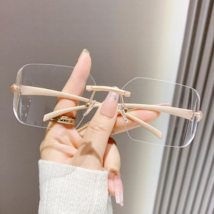 Lunettes de soleil carrées sans monture avec branches dorées pour un look futuriste