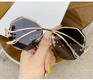 Detailed view of metal half-frame sunglasses with sparkling diamond accents and gradient lenses
