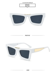 Detail view of white cat-eye sunglasses with grey lenses and gold metal accents
