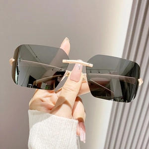 Lunettes de soleil carrées sans monture avec branches en métal doré et verres gris