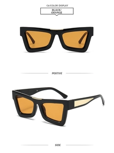 Detail of vintage cat-eye sunglasses with black frame, orange lenses, and gold metal trim