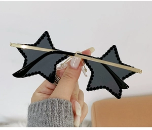 Détail de lunettes de soleil sans monture en forme d'étoile avec strass noirs et métal doré