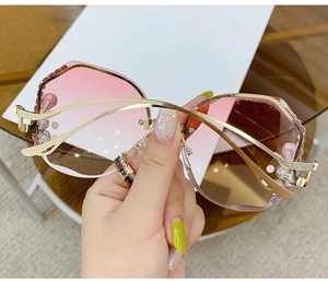 Detailed view of pink gradient lenses with rhinestones and golden wavy metal temples